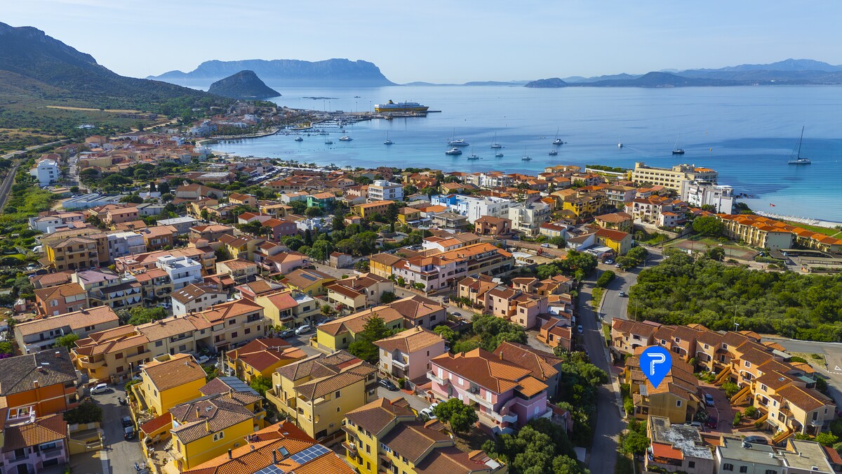The centre of Golfo Aranci with colourful houses and turquoise sea, a Gallura fishing village