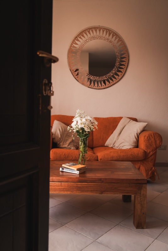 The elegant living area of a Propertize boutique apartment in the city of Olbia, with a sofa and design details