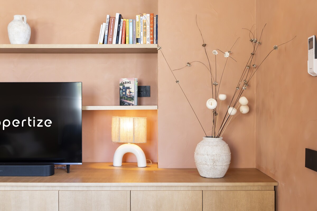A living-room corner with a Propertize TV and a design lamp in an apartment in Cagliari