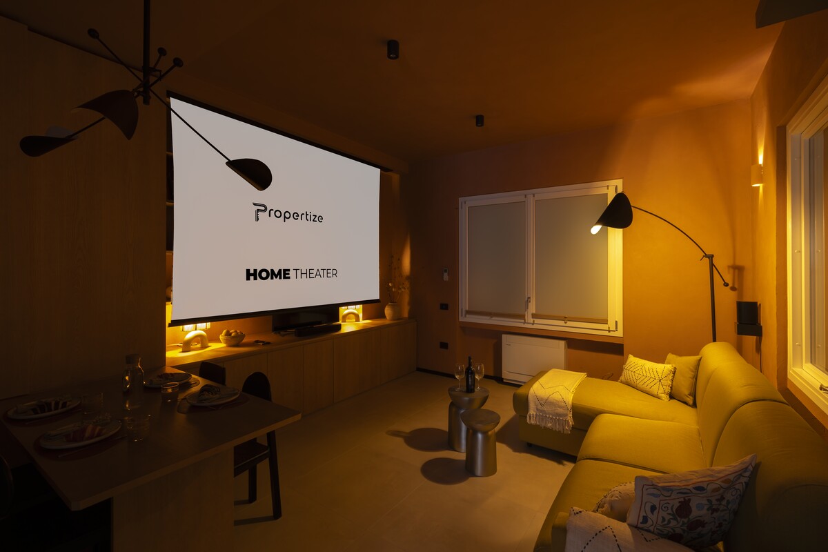 Private home cinema with a projector and a yellow sofa in a Propertize apartment in Cagliari