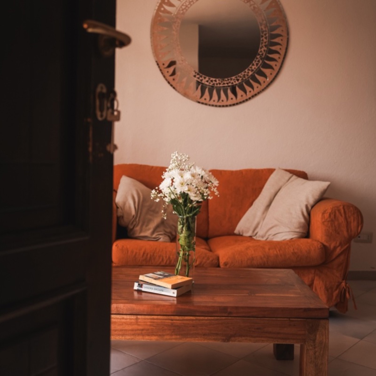 Living-room corner of a Propertize holiday home with a sofa, fresh flowers and a welcoming atmosphere